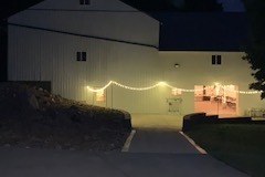 Exterior of barn with concrete patio and lights