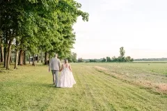 Couple Holding Hands behind woods along field